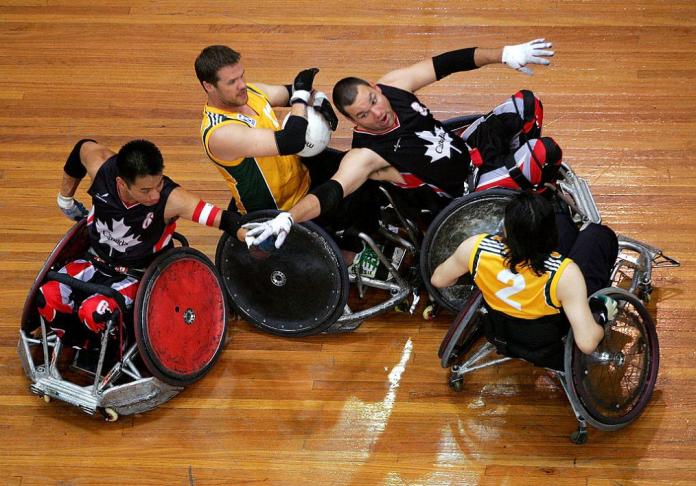 Four wheelchair rugby players in action